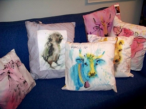 Painted and printed pillows on blue sofa