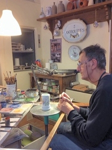 Artisan painting a ceramic piece