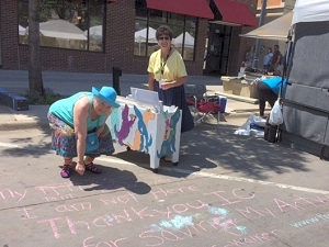 Jo chalks a thank-you to Iowa City residents during 2016 Iowa Arts Festival