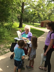 Fellow path pedestrians watch Jo Myers-Walker sketching in Iowa City