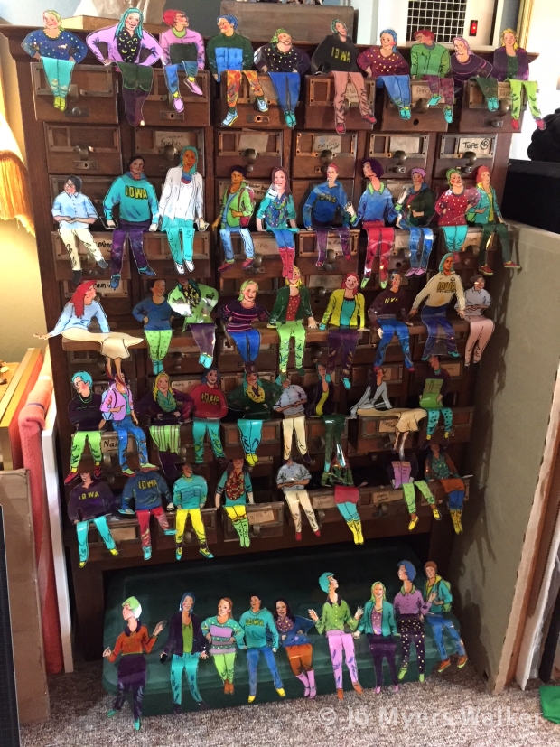 Sitters, slumped acrylic sculptures by Jo Myers-Walker, shaped and painted as college students and sitting on card catalog drawers