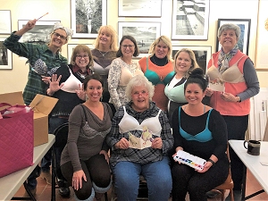 Class members showing bras they are donating to Free the Girls