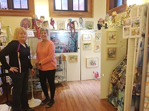 Friends Jeanette and Joan help set up Jo Myers-Walker's booth at the 2019 Eastside Artists Show and Sale in Iowa City