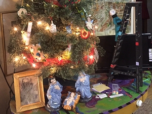 Ceramic nativity scene overseen by a small "alien" doll