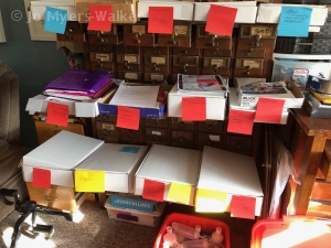 Drawers of a vintage wooden card catalog serve as support for boxes organizing documents and artwork by Jo Myers-Walker