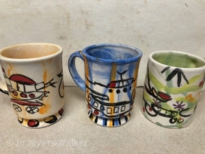 Colorful mugs decorated with a child's drawings
